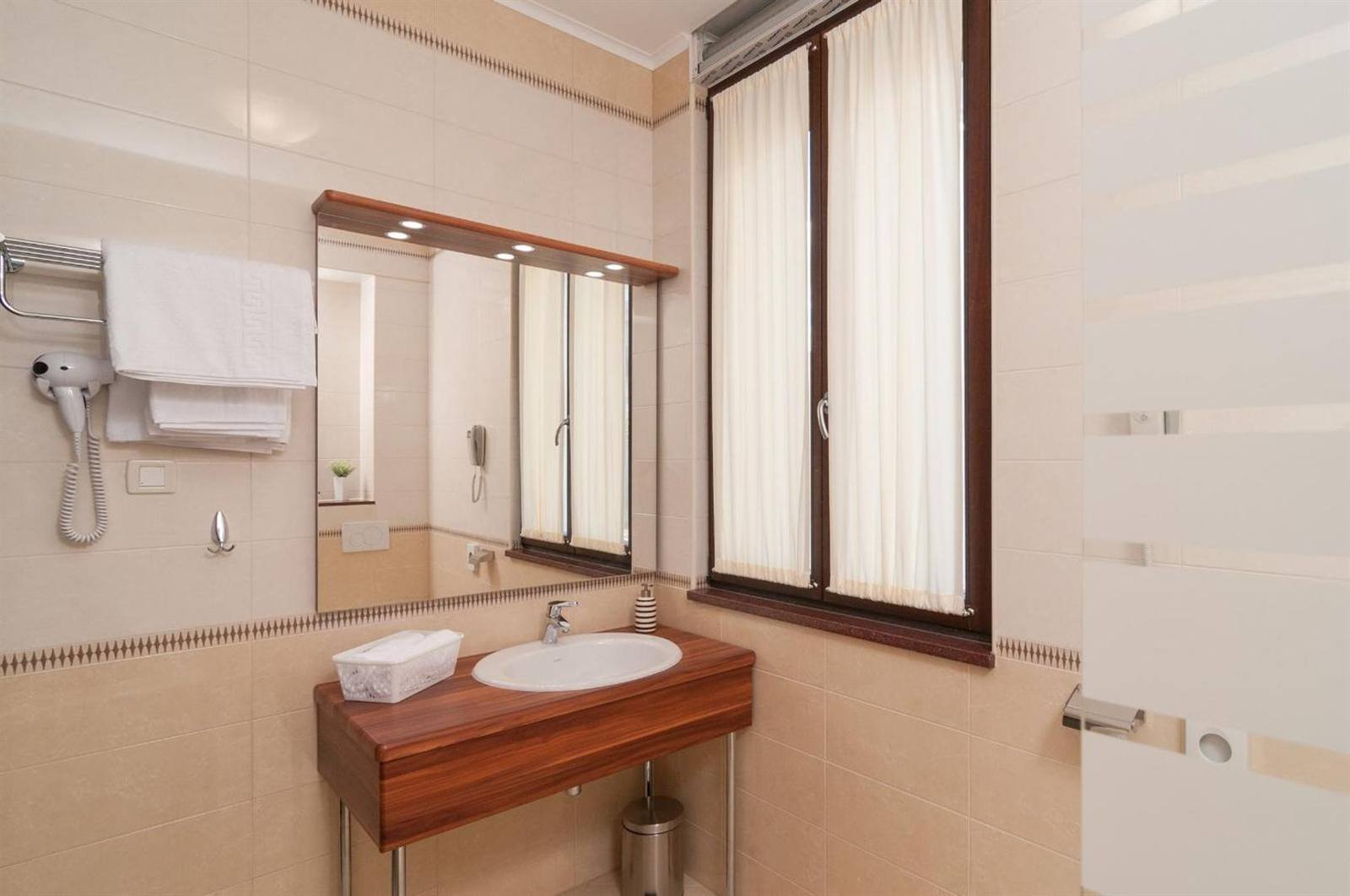 Bathroom with a vanity, mirror, towels and a hairdryer